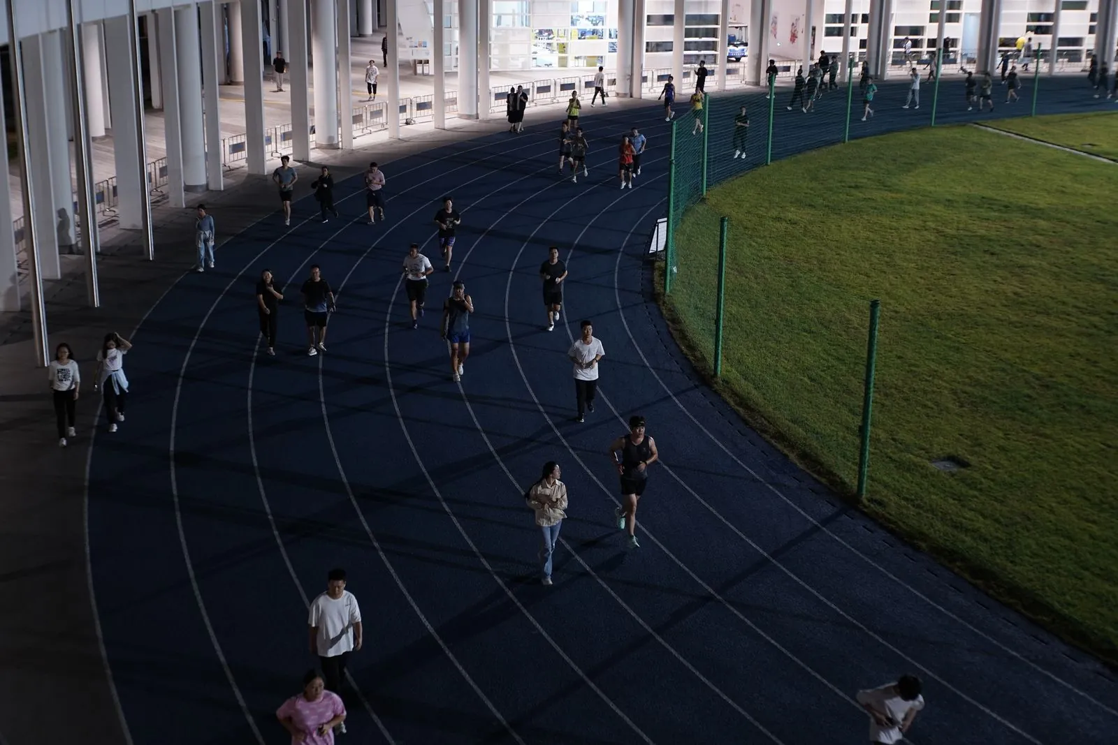 Groupe de coureurs sur une piste urbaine au crépuscule