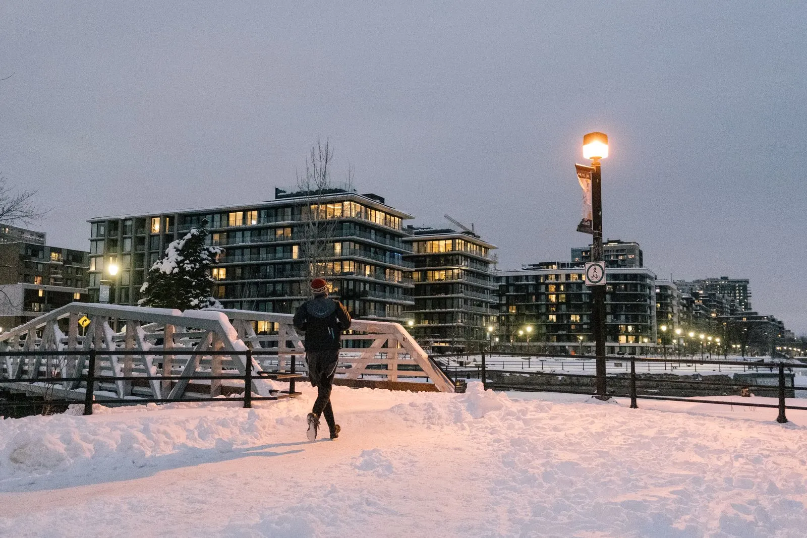 Coureur traversant un pont enneigé à Paris au crépuscule