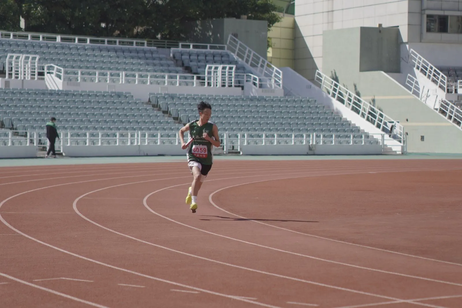 Coureur en pleine foulée sur une piste d'athlétisme extérieure