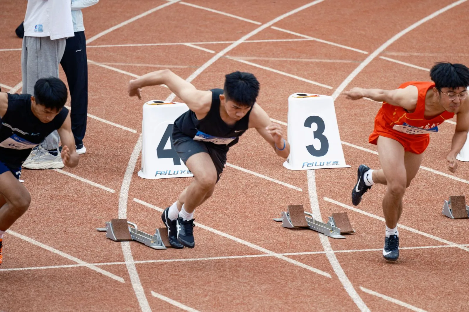 Jeunes sprinteurs en position de départ sur une piste d'athlétisme