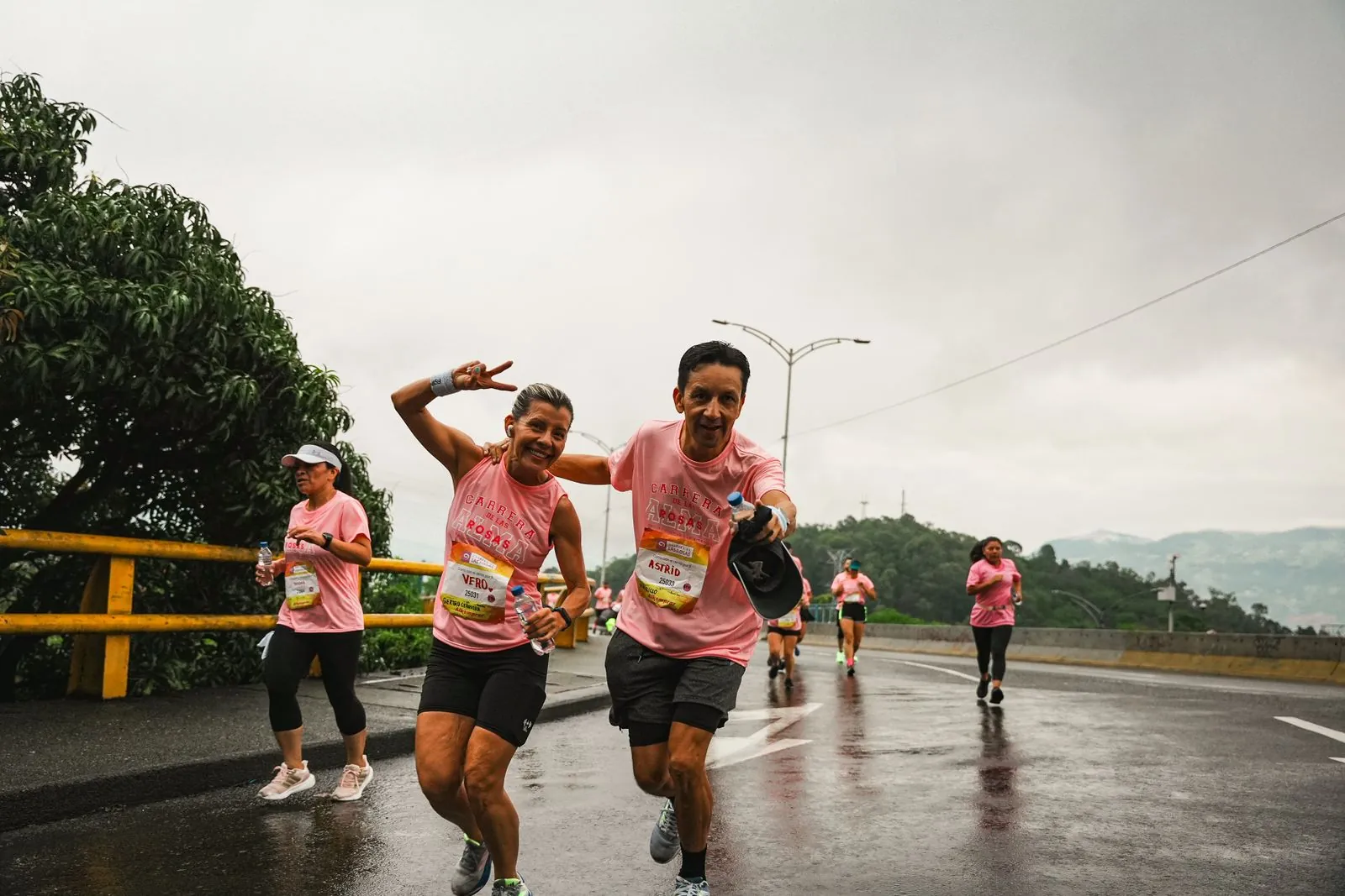 Des coureurs souriants sous la pluie pendant une course