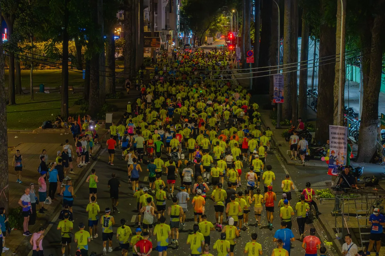 Un grand groupe de coureurs traverse la ville de nuit
