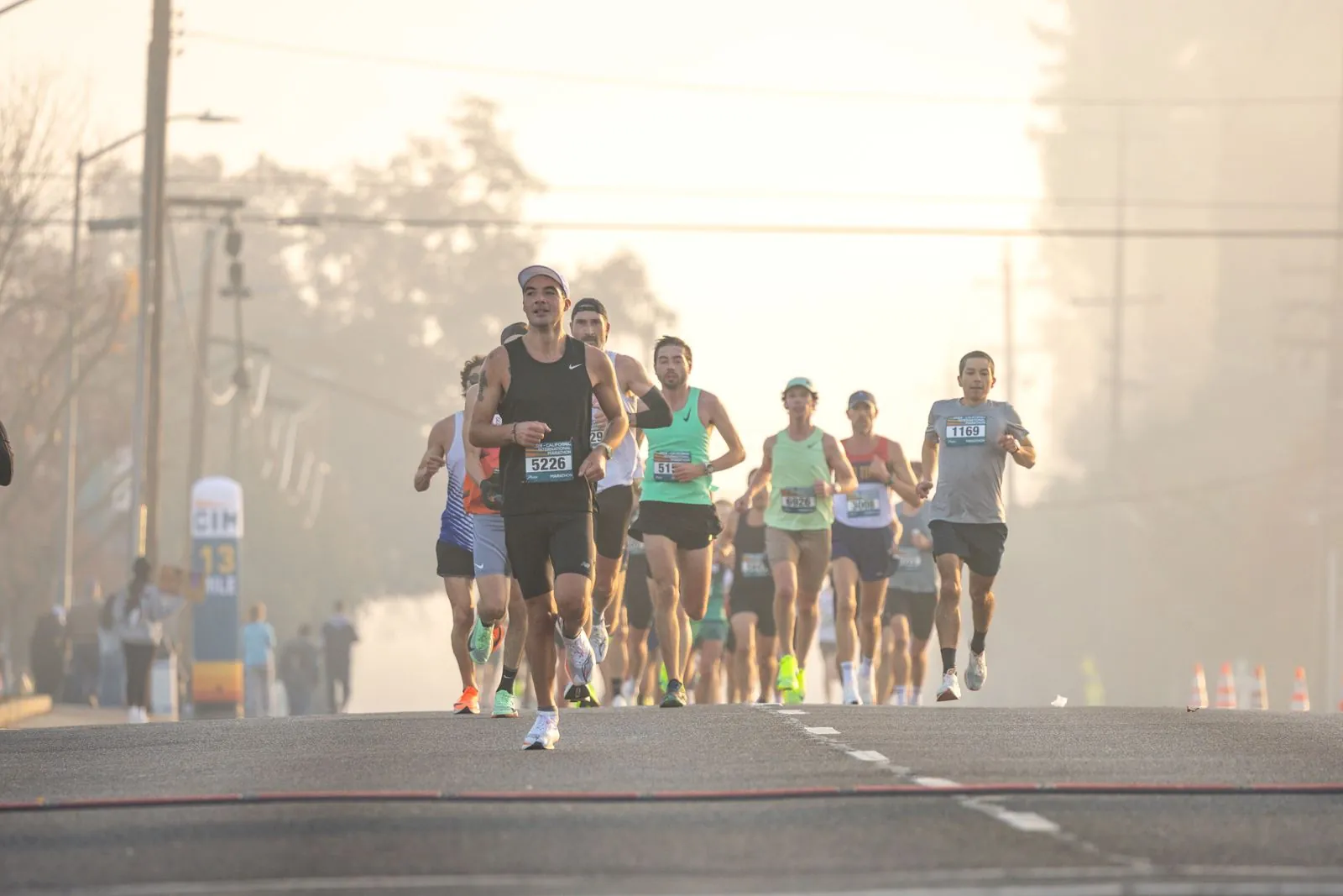 Groupe de marathoniens courant dans la brume du petit matin